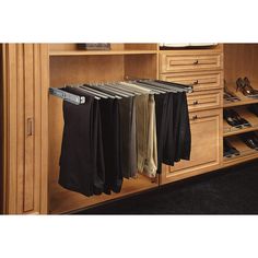 an open closet with several pairs of pants and shoes hanging on the rails in front of it