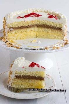 a cake with white frosting and red sprinkles sitting on a plate