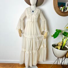 🌾 1970's Vintage CANDI of CALIFORNIA Cream Gauze Smocked Bell Sleeve Prairie Dress XS/S Summer is coming and Wedding Season is here! This Bohemian gown is everything you need to stay chic and cool in the warmer months! Tiered, flowing skirt is adorned with a back sash, back zipper, crochet lace trim and lightweight, gauzy, cream cotton. The skirt is also fully lined in cream acetate. The empire bust is absolutely beautiful in a smocked design with plunging neckline and delicate tie. The sleeves are fitted and flow out to handkerchief bells for a dramatic, gorgeous look. Paper tag & Candi Jones tag are intact at the neckline. Perfect with stone jewelry, sandals and broad rimmed hats! CONDITION- Freshly laundered & ready to wear! One TINY, faint brown spot on the skirt.  MEASUREMENTS- Bust- Off White Bohemian Maxi Dress For Daywear, Big Poofy Dresses, Zipper Crochet, Sleeves Wedding Gown, Poofy Dresses, Cotton Wedding Dresses, Grunge Dark Academia, Bohemian Gown, Poofy Dress