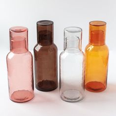 three different colored glass bottles sitting next to each other