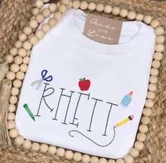 School days are cool days when you’re wearing a fun shirt like this! Each mini school supply item will be added around the name. No two shirts will look identical. When ordering an embroidered item, please specify your desired monogram initials or name, monogram font & thread color. All of the monogram options can be found here. Also, please note any additional special requests in the box provided. We will try our best to comply. School Spirit T-shirt With Embroidered Graphics, Customizable Cute Tops For School, Cute Customizable Tops For School, Cotton T-shirt With Embroidered Text For School, Casual School T-shirt With Embroidered Graphics, Cotton T-shirt With Letter Embroidery For School, School T-shirt With Letter Embroidery, Cotton T-shirt With Embroidered Text, Preppy Cotton School Shirt