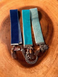 three pieces of jewelry sitting on top of a wooden table