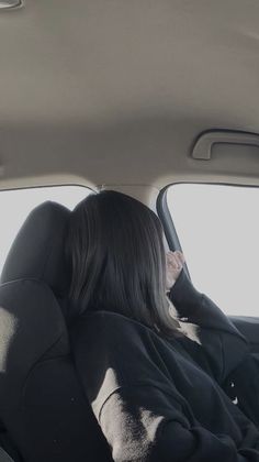 a woman sitting in the back seat of a car