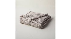 a knitted blanket laying on top of a white wall