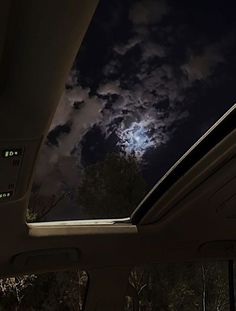 the full moon is shining brightly in the night sky from inside a car's windshield