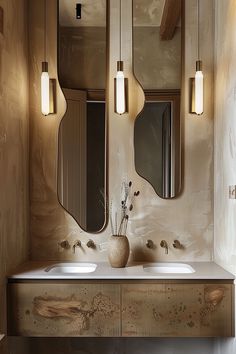 a bathroom with two sinks, mirrors and lights on the wall above it's counter