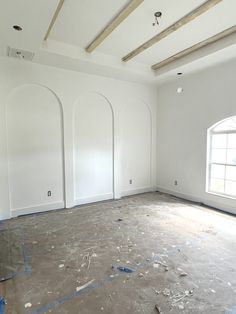 an empty room with white walls and blue tape on the floor in front of a window