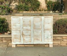 an old wooden cabinet sitting in front of a stone wall