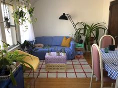 a living room filled with furniture and lots of plants