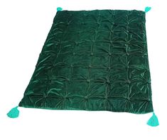 a green blanket with tassels on it