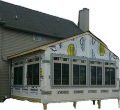 a house under construction with windows and siding