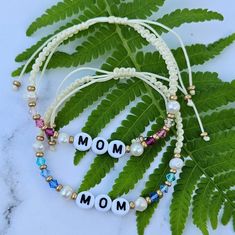 "MOM" Bracelet  Makes a wonderful gift for Mom. Whatever the occasion: Mother's Day, mom's birthday,  and holiday, a new mom to be or any day you want to make her feel special. This bracelet is made with fresh water pearls, genuine czech crystals in assorted colors, gold seed beads and it features the word "MOM" on a durable nylon string. You can also personalize the word if you want something different.  You can simply use the personalization box to indicate other wise it will come with the wor Mom Bracelet, Mom's Birthday, Moms Bracelet, Mom To Be, Personalized Gifts For Mom, Fresh Water Pearls, Czech Crystal, Water Pearls, Feel Special