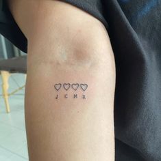 a woman's arm with three small hearts on it and the word jcm written in black ink