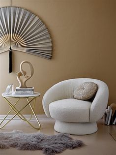 a white chair sitting next to a table on top of a hard wood floor in a living room