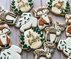 many decorated cookies with animals and words on them sitting on a wooden table next to each other