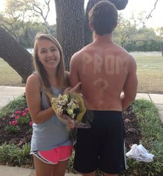 a young man and woman standing next to each other with the word prom written on their back