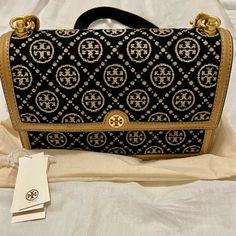 Tory Burch T Monogram Chenille Shoulder Bag In Black/New Cream. Comes With Removable, Adjustable Webbing Strap And An Additional Adjustable Leather Strap. Bag Is In Monogram, Chenille Jacquard Fabric With Leather And Gold Tone Hardware, And A Center Zip Pocket Divides The Interior. The Bag Is In Like New Condition, And Was Only Carried One Time For A Couple Of Hours. Comes With The Tag And Dust Bag. Leather Strap Bag, T Monogram, Strap Bag, Webbing Strap, Tory Burch Bag, Jacquard Fabric, Black Cream, New Black, Tory Burch