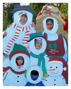 some kids are posing with snowmen in front of them