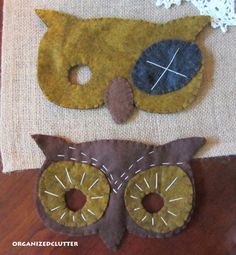 two felt owls sitting on top of a wooden table