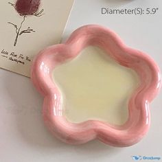 a pink flower shaped plate next to a card