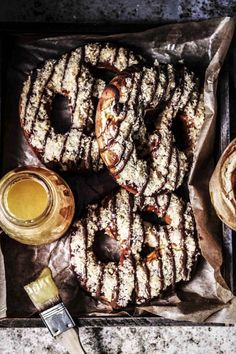 there are many donuts on the table with some butter and honey in front of them