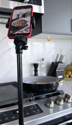 a tripod mounted to the side of a stove with food on it's plate