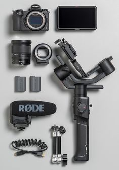 various cameras and accessories laid out on a white surface with the words rode above them