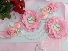 some pink flowers and pearls on a table