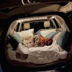 the trunk of a car filled with blankets and pillows