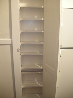 an empty pantry with white shelves and no door for the refrigerator or freezer to be opened