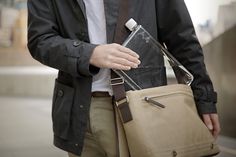 a man carrying a bag with an electronic device in it's back pocket,