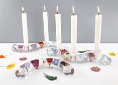 a group of four candles sitting next to each other on top of a white table