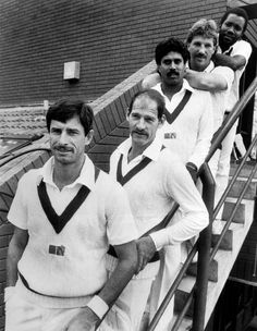 four men in white uniforms are standing on the stairs