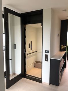 an empty room with black and white doors, bookshelves, and a window