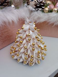 a white and gold christmas tree on a table