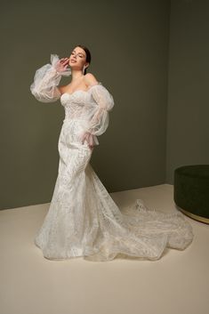 a woman in a wedding dress posing for the camera with her hands on her face