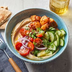 a blue bowl filled with food next to a fork and napkin on top of a table