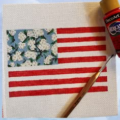 an american flag painted with acrylic paint next to a brush and glue bottle