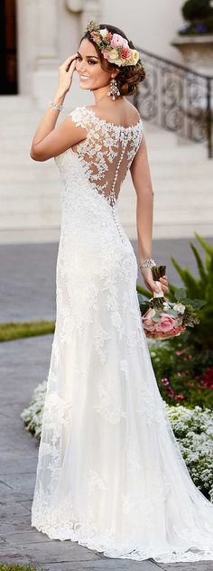 a woman in a wedding dress is looking at her cell phone while standing on the sidewalk