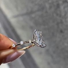 a person holding a diamond ring in their hand