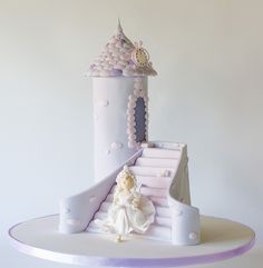 there is a cake that looks like a castle with a princess in it on top