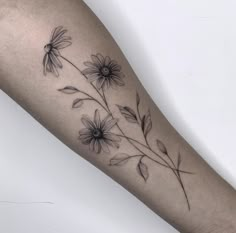 a black and white photo of a flower on the left arm, with leaves coming out of it