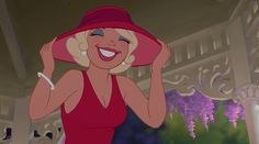 a woman in a red dress and pink hat smiles as she holds her hands up to her head