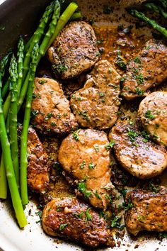 some meat and asparagus are in a skillet