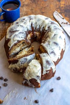 a bundt cake sitting on top of a table next to a cup of coffee