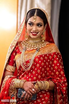 a woman in a red and gold bridal outfit