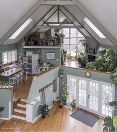 an open floor plan with stairs leading up to the upper level and lots of greenery