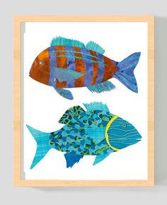 two blue and orange fish on white paper with wood frame in front of grey wall