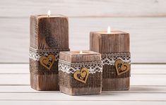 three wooden candles with hearts on them