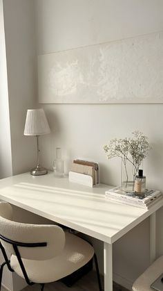 a white desk with two chairs next to it and a lamp on the side table